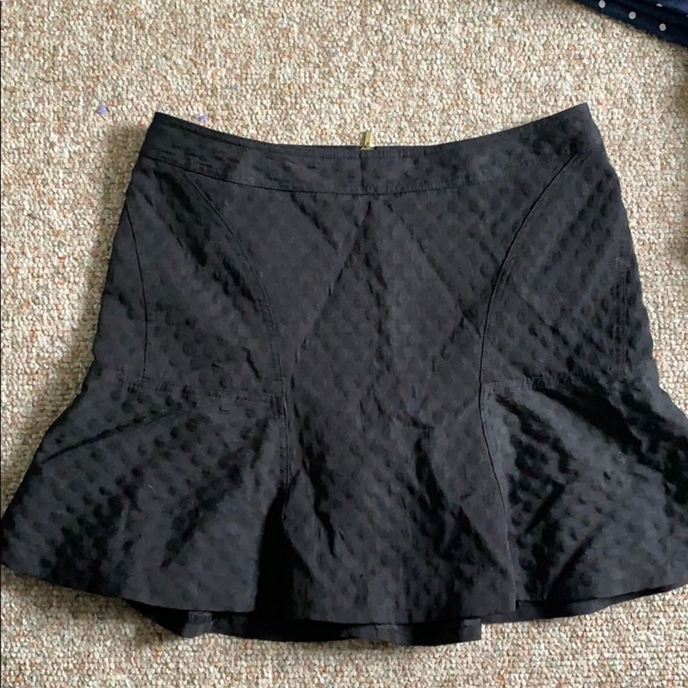 Black pleated skirt. Risen polka dots.